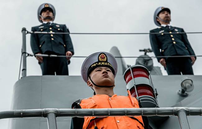俄罗斯摄影师仰拍角度下，庄严肃穆的中国海军官兵。有意思的是甲板采用了钢制栏杆，而副炮位置采用了立杆+钢索的护栏，这种临时护栏可以随时放倒拆卸。